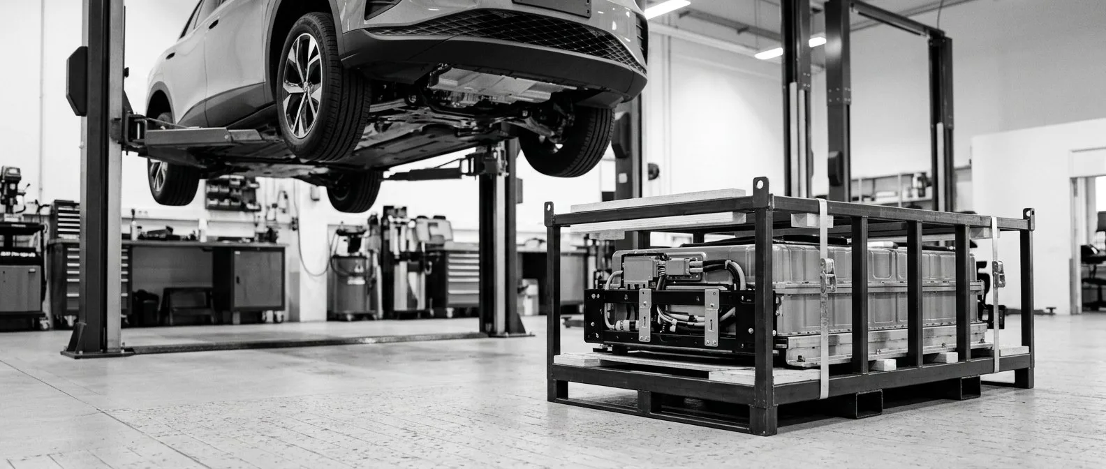 Replacement electric vehicle battery pack in a shipping frame on a workshop floor