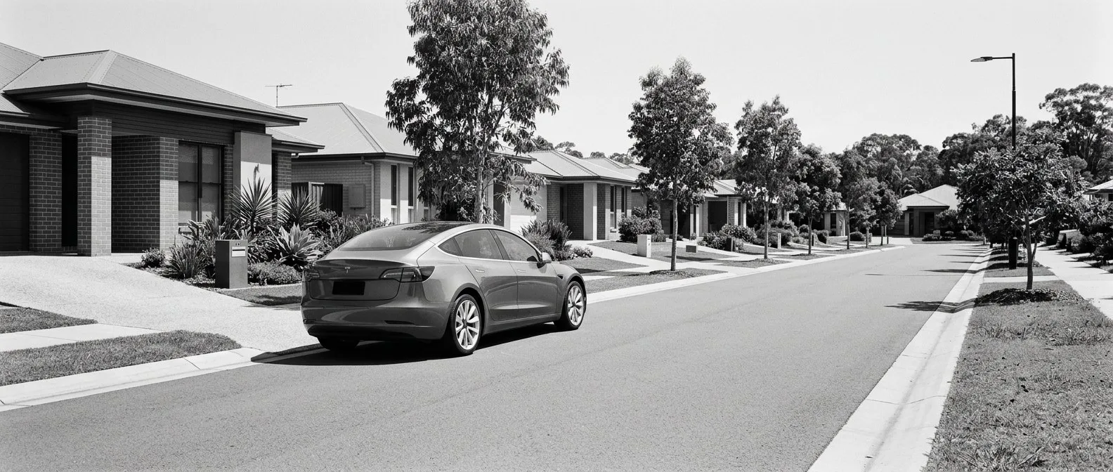 Electric car on a suburban Queensland street of low-set brick homes