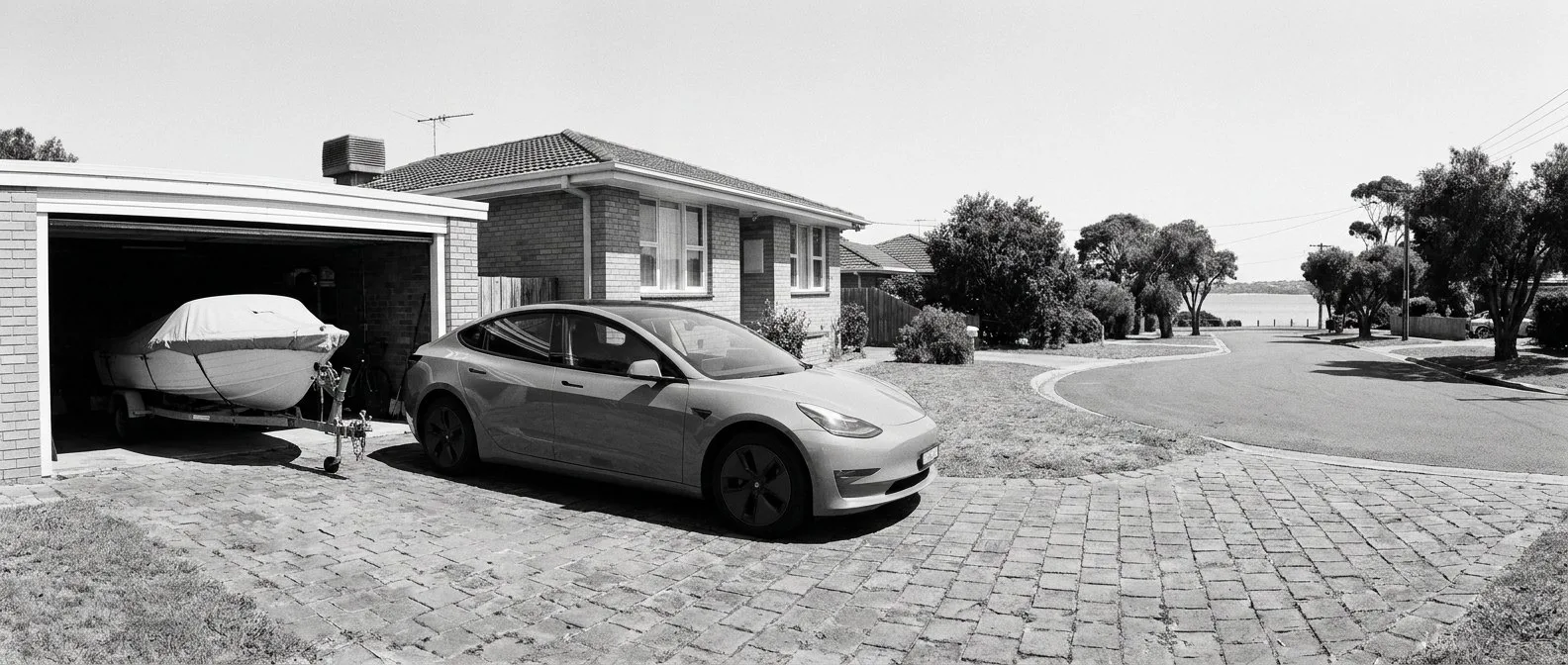 Electric car on a driveway beside a garage in the Sutherland Shire