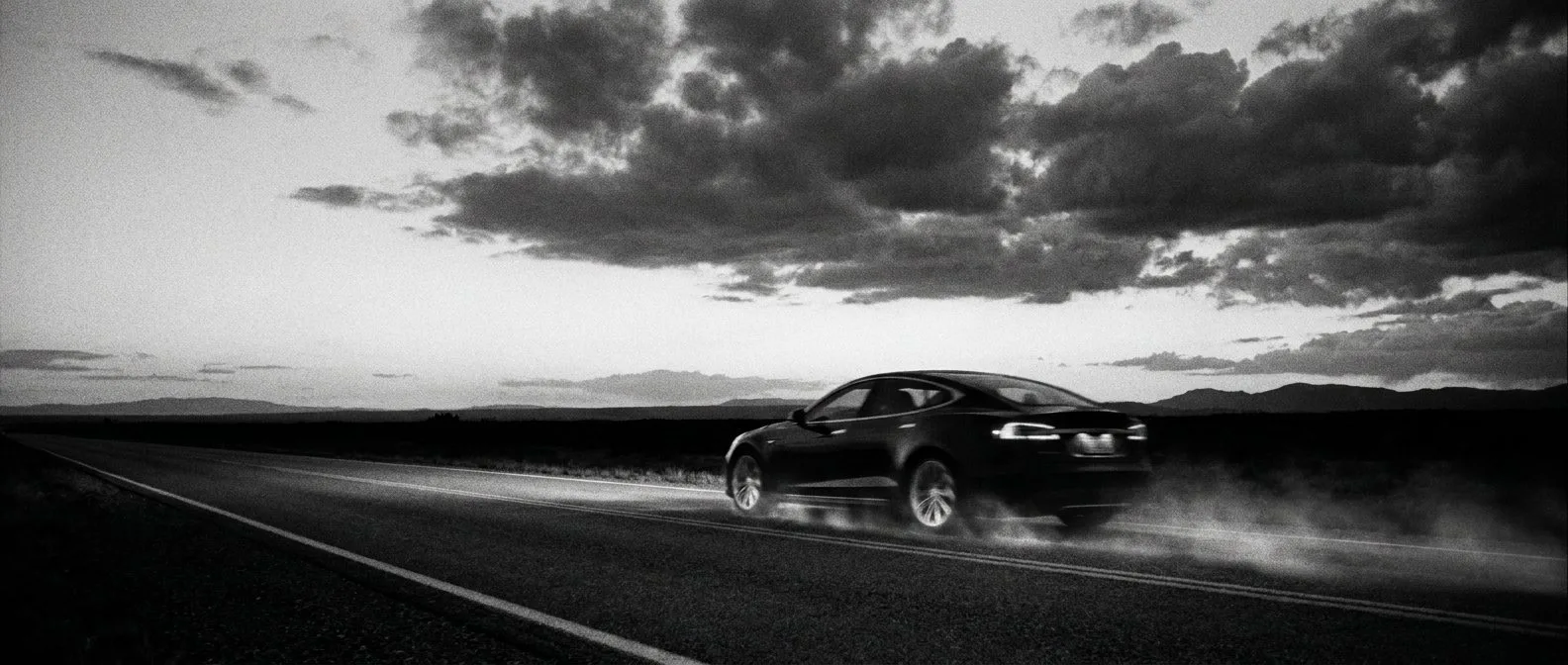 Electric car travelling on an open highway at dusk
